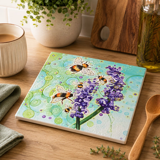 Bumblebee and Lavender ceramic trivet on wooden kitchen worktop beside coffee cup, wooden spoon and chopping board, teal bubble-effect background