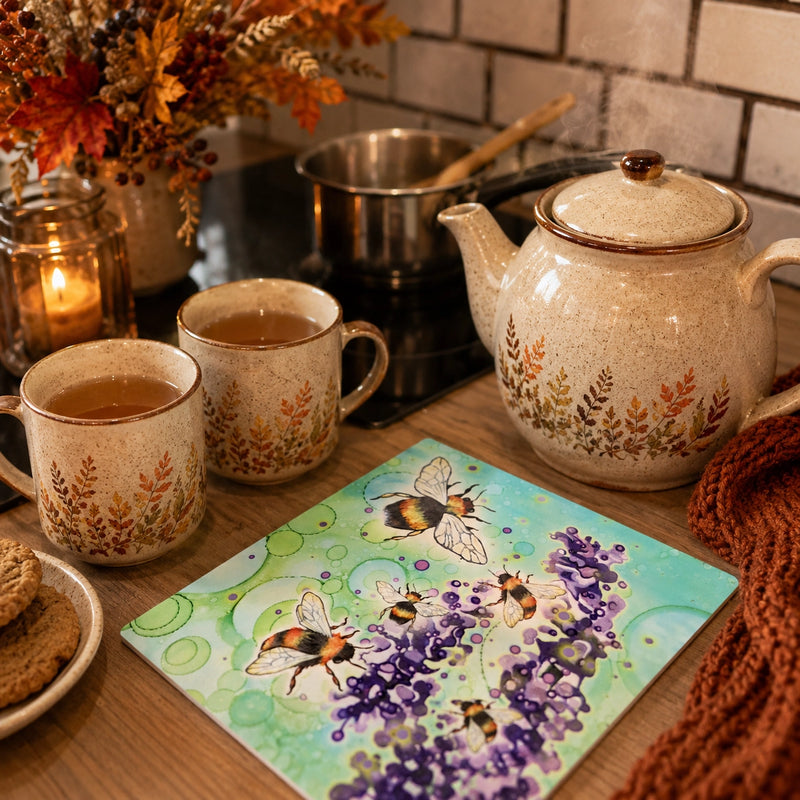 Bumblebee and Lavender ceramic trivet on kitchen worktop beside teapot and mugs in cosy autumn kitchen setting