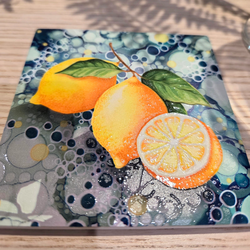 Close-up of lemon ceramic coaster showing lemon design with teal bubble-effect background