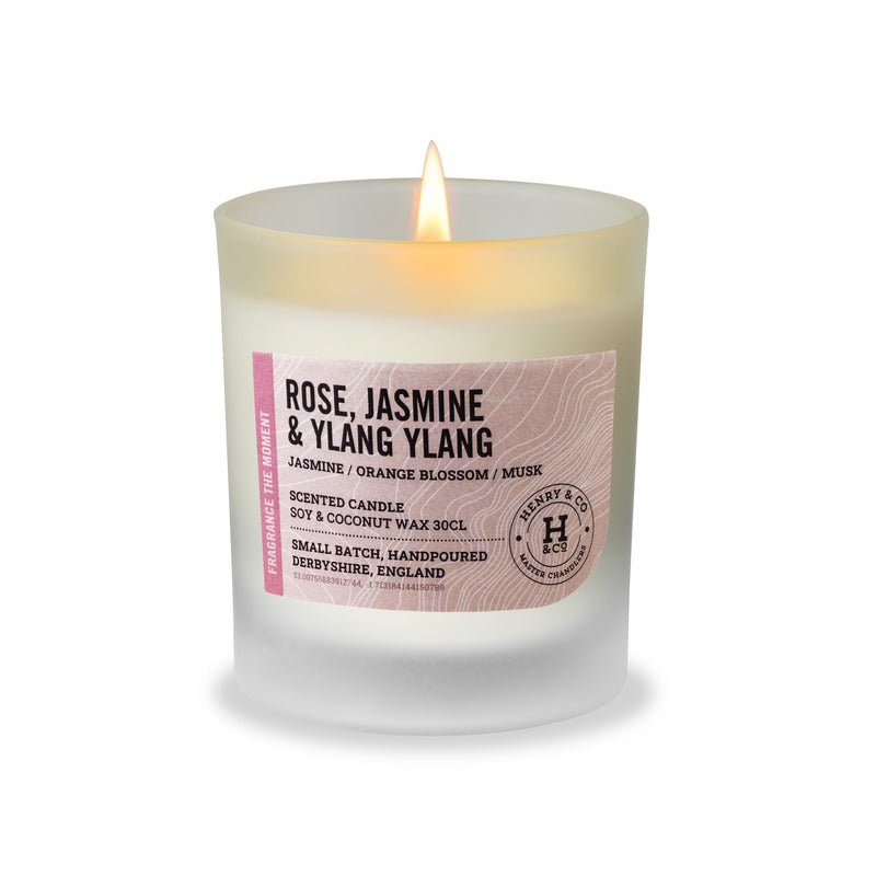 Henry & Co Rose Jasmine and Ylang Ylang scented candle 30cl lit in a frosted glass vessel with bamboo lid on a white background