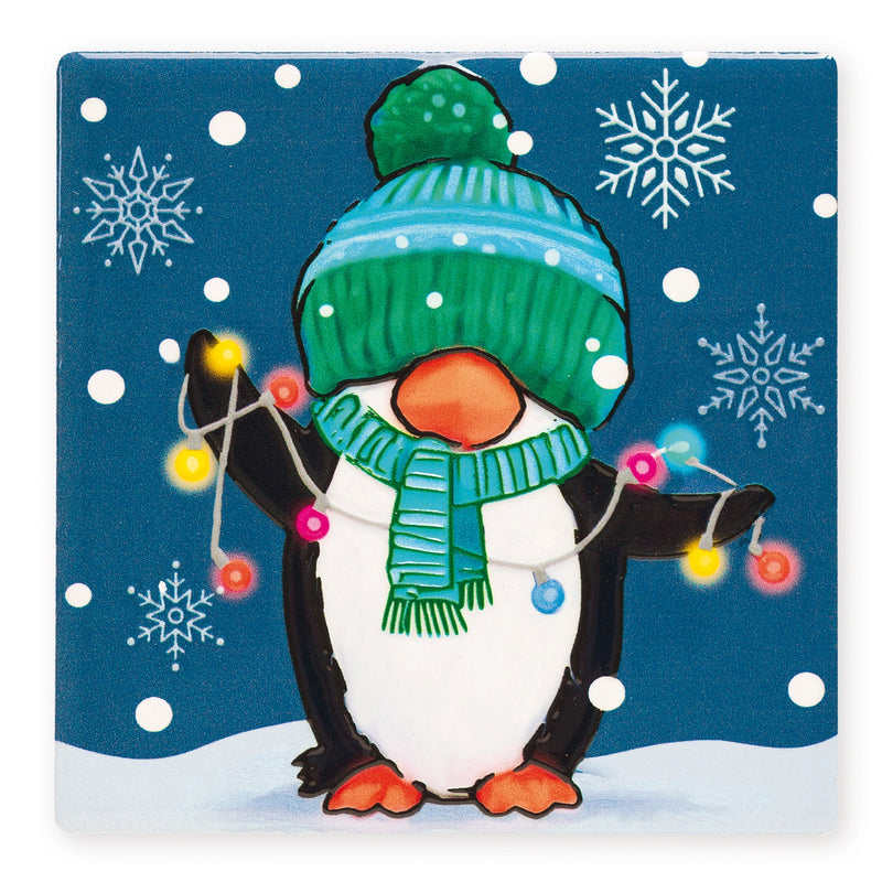Ceramic Christmas coaster featuring a penguin in a bobble hat and scarf holding a string of fairy lights, surrounded by snowflakes.