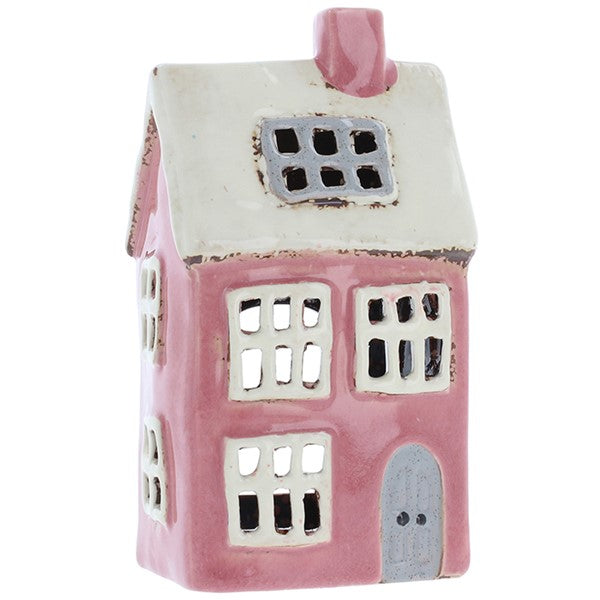 Handcrafted ceramic bright pink & white cottage tealight holder with white roof, pink chimney and grey arched door, on a white background