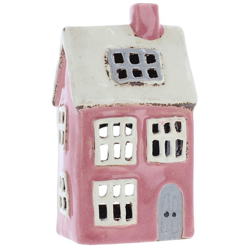 Village Pottery Bright Pink & White tealight holder, tall pink ceramic cottage with cream roof, pink chimney, multiple white-framed windows, dormer window in roofline and grey arched door, white background