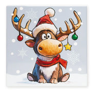 Square Christmas trivet featuring a seated reindeer wearing a Santa hat and scarf, with baubles and a star hanging from its antlers and snowflakes in the background.