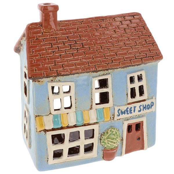 Village Pottery Sweet Shop ceramic tealight holder with light blue exterior, striped awning and pot plant by the door, front view on white background