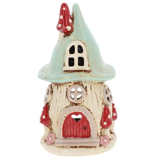 Handcrafted ceramic aqua mushroom house tealight holder with soft aqua pointed roof, red arched door, toadstool chimney and red and white toadstools around the base, on a white background