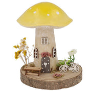 Spring Folk Art Mushroom House ornament with yellow pastel cap on wooden log base with miniature bicycle, bench and dried flowers