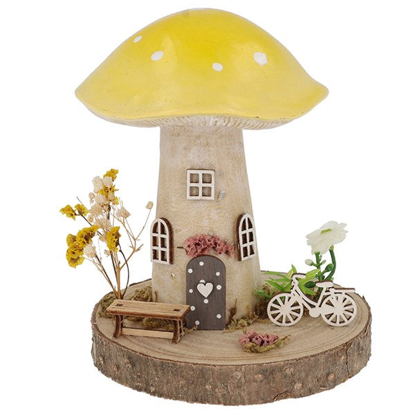 Spring Folk Art Mushroom House ornament with yellow pastel cap on wooden log base with miniature bicycle, bench and dried flowers