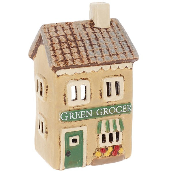 Village Pottery Greengrocers ceramic tealight holder with green door, striped awning and window box detail, front view on white background