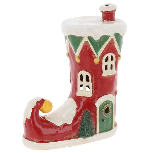 Village Pottery Christmas elf boot tealight house, red ceramic boot with green zigzag trim, arched windows, green door with wreath, Christmas tree and gold bell at curled toe, white background