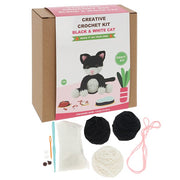 Contents of the Creative Crochet Black and White Cat kit showing yarn, hook, stuffing and instructions