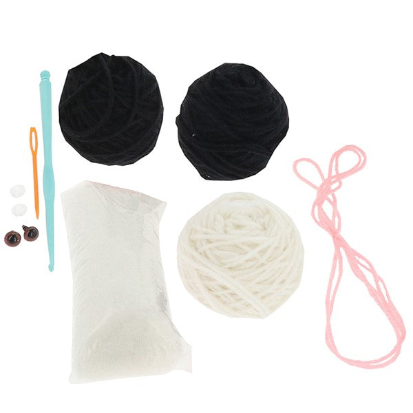 Contents of the Creative Crochet Black and White Cat kit showing yarn, hook, stuffing and instructions