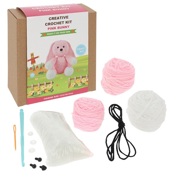 Contents of the Creative Crochet Pink Bunny kit showing pink yarn, hook, stuffing and instructions

