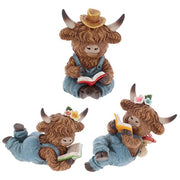  Three highland cow reading figurines in denim dungarees — one sitting with straw hat reading a red book, two lying down with flower accessories reading yellow and green books