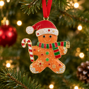 Gingerbread man Christmas tree hanging decoration with Santa hat and candy cane, hanging on a Christmas tree with warm golden bokeh fairy lights