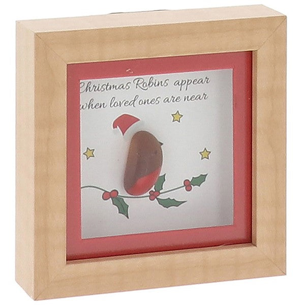 A small square natural wood box framed pebble art picture with a pebble robin wearing a red Santa hat perched on an illustrated holly branch with berries and gold stars, and the sentiment "Christmas Robins appear when loved ones are near"