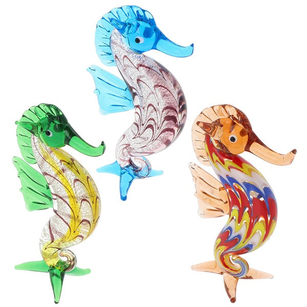 Three glass seahorse figurines in blue, green and orange, presented on a white background