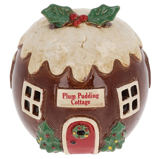 Village Pottery Plum Pudding Cottage tealight house, round brown building with cream sauce drip roof, holly and berry topping, red arched door with wreath and holly bushes, white background