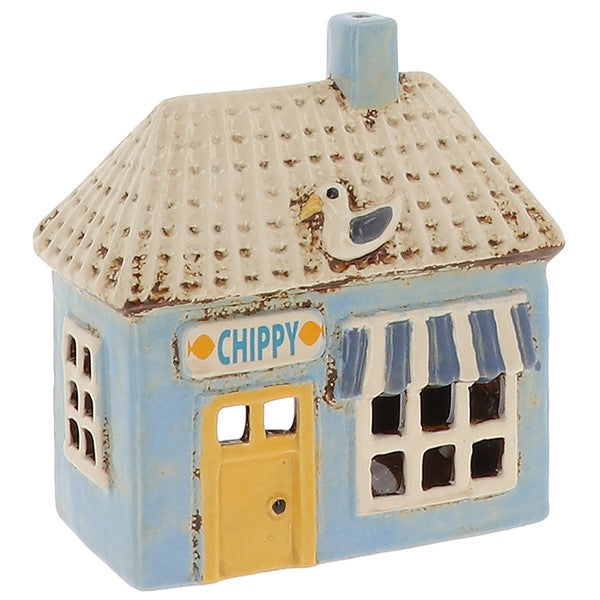 Village Pottery Chippy ceramic tealight holder with pastel blue exterior, yellow door, striped awning and seagull on roof, front view on white background