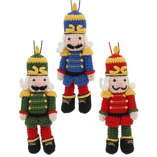 Three knitted nutcracker hanging decorations in blue, green and red with gold trim, plumed hats and black boots
