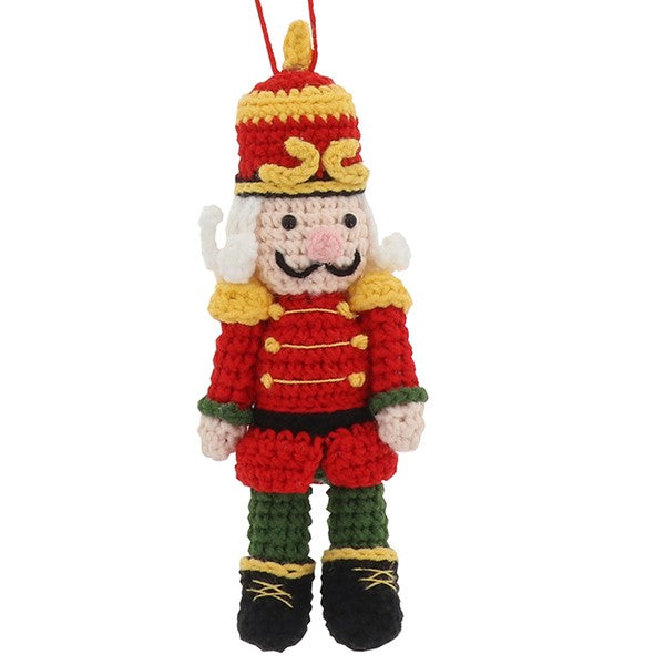 Knitted nutcracker hanging decoration in red uniform with gold trim, plumed hat and black boots