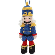 Knitted nutcracker hanging decoration in blue uniform with gold trim, plumed hat and black boots