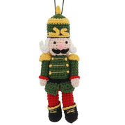 Knitted nutcracker hanging decoration in green uniform with gold trim, plumed hat and black boots