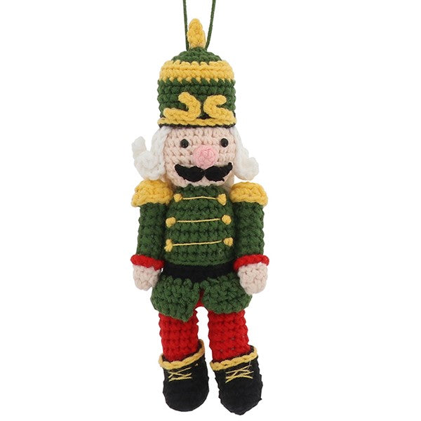 Knitted nutcracker hanging decoration in green uniform with gold trim, plumed hat and black boots