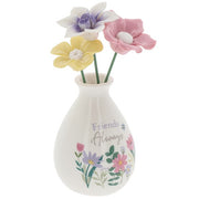 Friends Always flower vase angled view showing pastel blooms and wildflower illustration detail around the base of the white bud vase