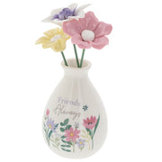 Friends Always flower vase angled view showing pastel blooms and wildflower illustration detail around the base of the white bud vase