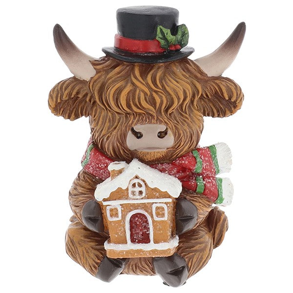 Merry Christmas Coos mini highland cow figurine wearing a black top hat with holly, holding a gingerbread house