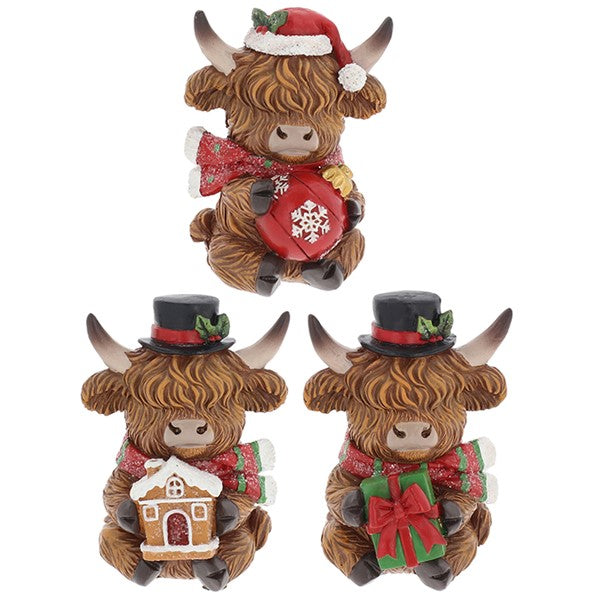 Three Merry Christmas Coos mini highland cow figurines — holding a bauble, a gingerbread house, and a wrapped present, each with shaggy fur detail and curved horns, 5 x 4.5 x 7cm