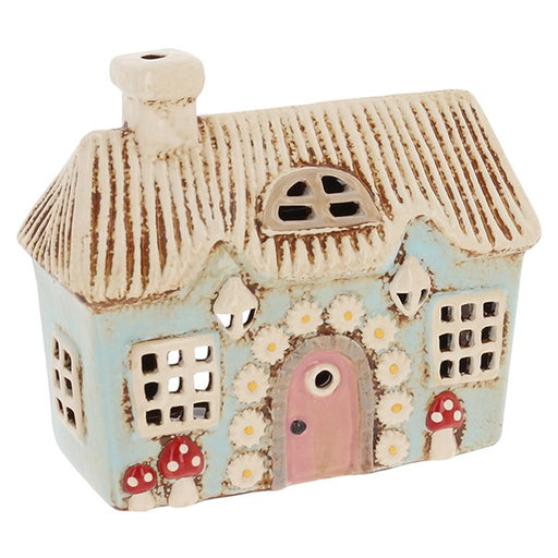 Village Pottery Flower Cottage ceramic tealight holder with duck-egg blue walls, pink arched door, daisy details and red toadstools