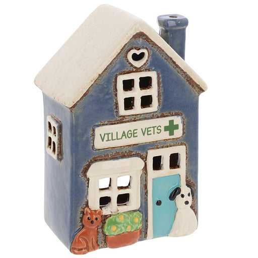 Angled view of Village Pottery village vets tea light holder showing blue chimney, heart cut-out at roof apex and cut-out windows