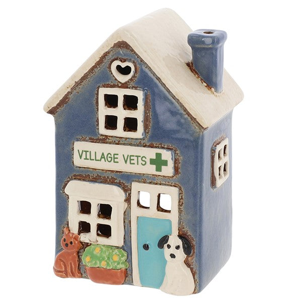 Village Pottery ceramic village vets tea light holder, blue two-storey building with white gabled roof, heart cut-out, blue door, Village Vets signage, ginger cat and white dog by the entrance 