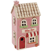 Angled view of Village Pottery wine bar tea light holder showing potted plant and climbing plant detail
