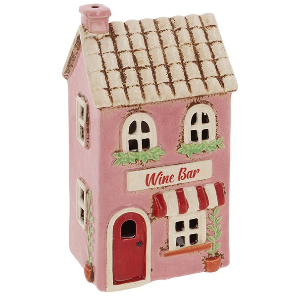 Angled view of Village Pottery wine bar tea light holder showing potted plant and climbing plant detail