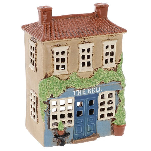 Village Pottery ceramic tea light holder shaped as The Bell pub, warm stone coloured two-storey building with terracotta roof, twin chimneys, blue door and ivy-covered frontage