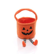 Pumpkin Halloween treat bag with jack-o'-lantern face, carry handle and black-and-white striped dangly legs with orange feet, white background