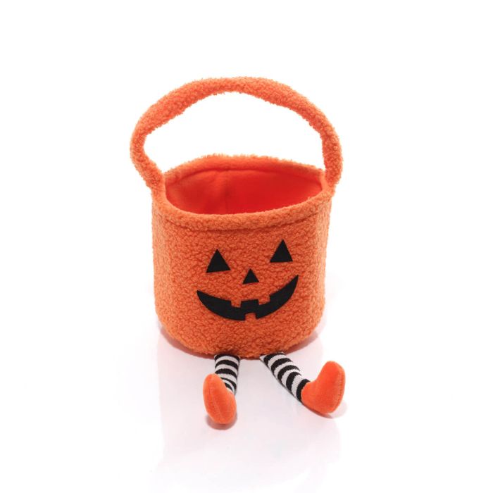 Pumpkin Halloween treat bag with jack-o'-lantern face, carry handle and black-and-white striped dangly legs with orange feet, white background