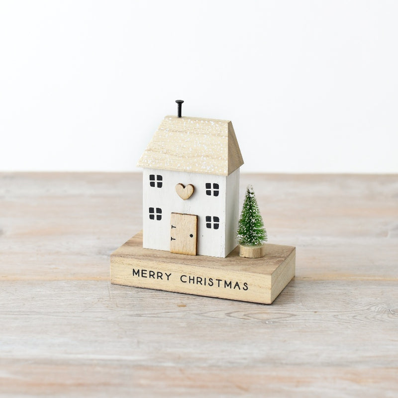 Quirky whitewashed wooden Christmas house decoration with snowflake roof detail, wooden heart, natural wood door and snow-dusted bottle brush tree, 12cm
