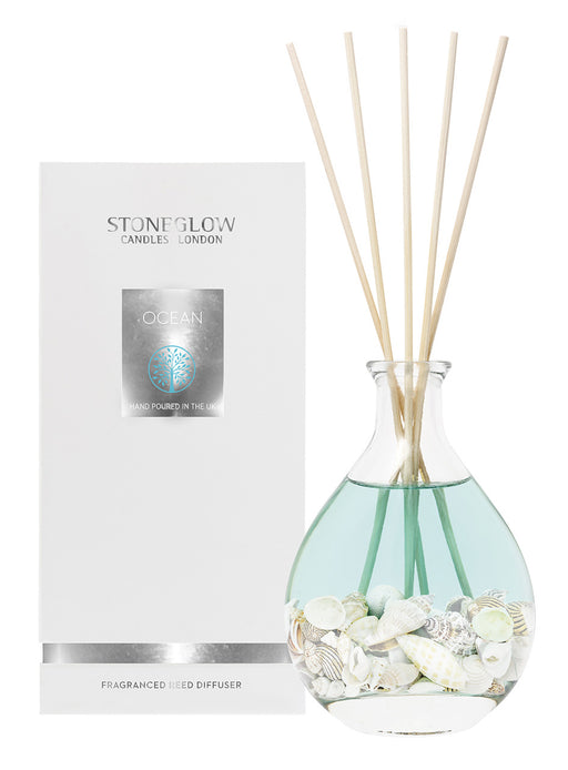 Stoneglow Nature's Gift Ocean Reed Diffuser in rounded glass vessel filled with seashells with rattan reeds, shown with white gift box