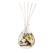 Close-up of Stoneglow Nature's Gift Lilac and Lavender Reed Diffuser showing dried florals and botanicals suspended in oil with rattan reeds