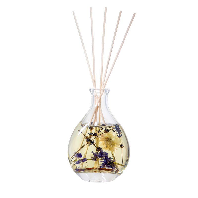 Close-up of Stoneglow Nature's Gift Lilac and Lavender Reed Diffuser showing dried florals and botanicals suspended in oil with rattan reeds