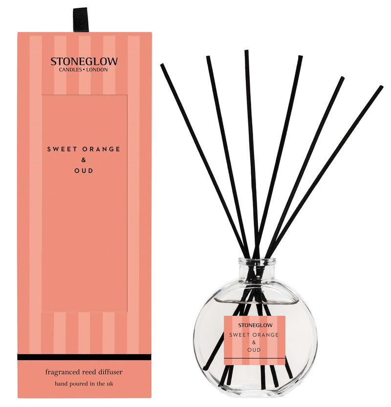 Stoneglow Modern Classics Sweet Orange and Oud Reed Diffuser in globe glass vessel with black reeds, shown with coral gift box