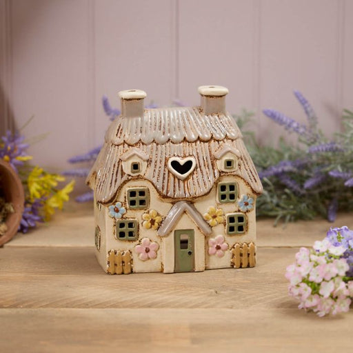 Cream stoneware floral thatched cottage tealight holder with embossed pastel flowers, heart cutout and picket fence, Stoneware Country Cottage Collection