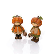 Two resin pumpkin figurines on a white background — a girl with plaited hair in a textured top and lace-trim skirt, and a boy in a textured gilet and trousers, each wearing a pumpkin hat with stalk and leaf detail and holding a pinecone