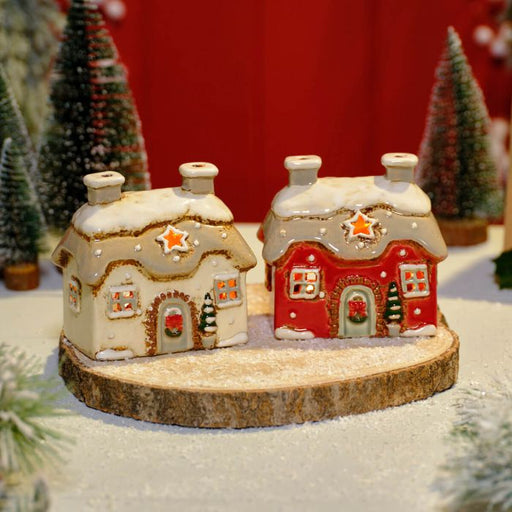 White and red stoneware Christmas cottage tealight holders side by side, Stoneware Country Cottage Collection