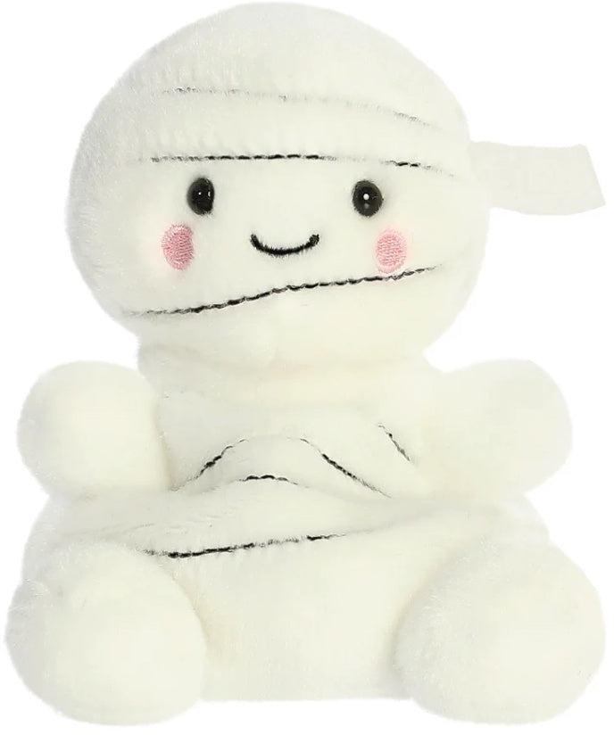 Brendan the Mummy Palm Pal a spooky-cute cream plush wrapped in bandage-style detail with dark stitch lines shiny black eyes rosy cheek circles and a sweet smile shown from the front