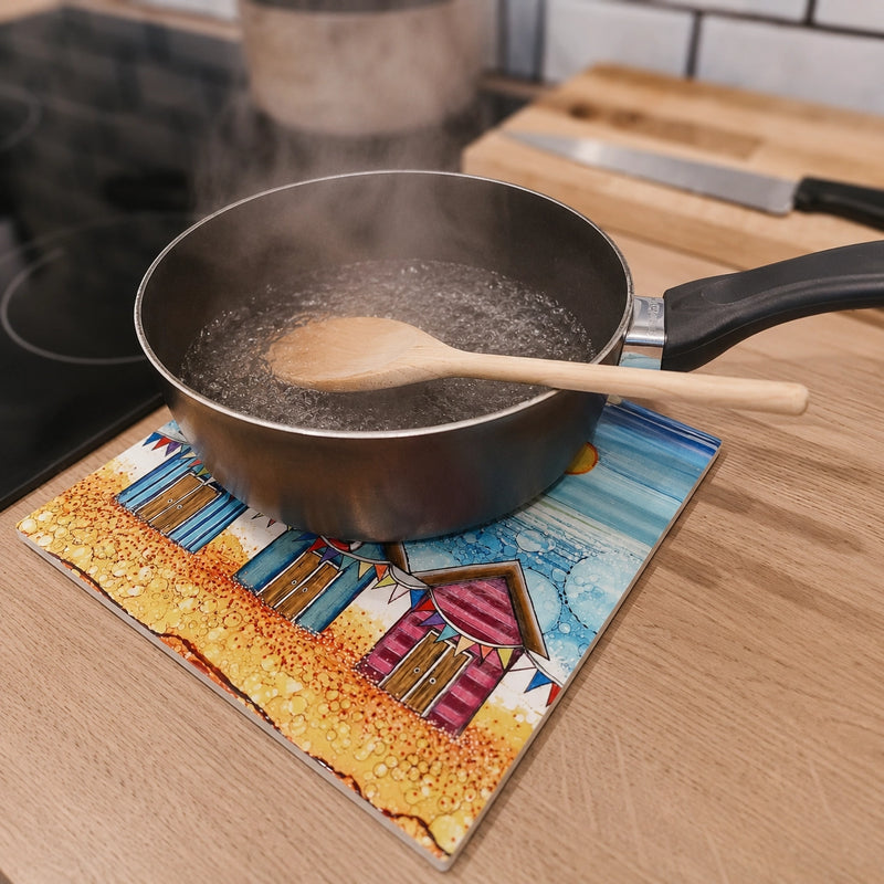 Boiling saucepan on Beach Hut and Bunting ceramic trivet on wooden kitchen worktop